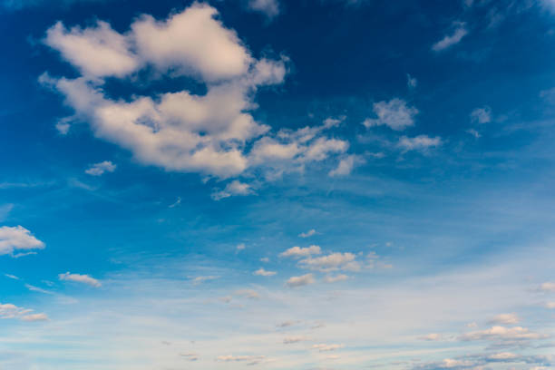 istock Airplane flying in the blue sky among clouds and sunlight 1376688183