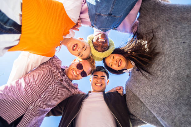 istock Multiracial friends hugging each other standing in circle looking at camera 1376689226