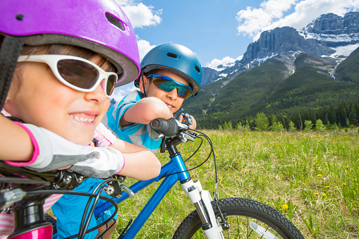 8/9 years old children riding bicycle at Banff National Park, Canada.