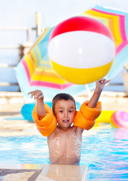 istock Boy playing in the swimming pool 1376706155