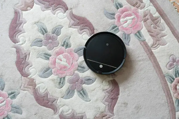 Photo of automatic remote house cleaning, robot cleaner at home on the floor