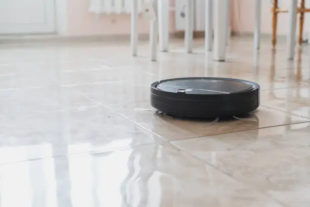 Photo of automatic remote house cleaning, robot cleaner at home on the floor