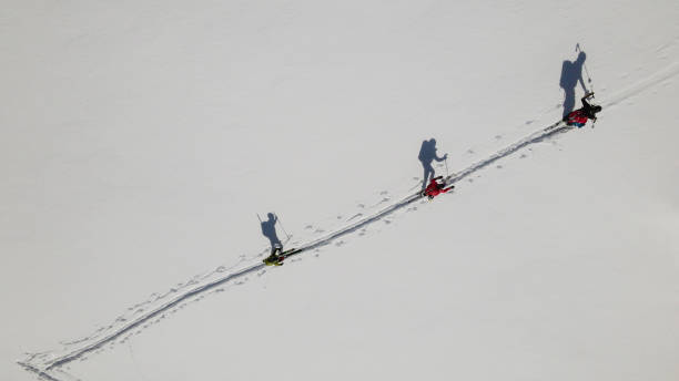 슬로프를 올라가는 스키 산악인의 공중 보기 - skiing snow ski slope sunlight 뉴스 사진 이미지