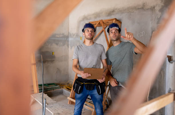 Team of Brazilian construction workers building a house and pointing away at the ceiling