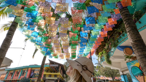 istock Tourist walking under papel picado (perforated paper) flags. 1376731901
