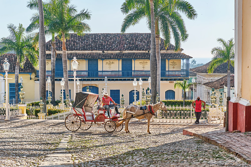 Trinidad, Cuba - February 12, 2022: Horse-drawn transport on old cobbled street in colonial style. Transport, travel concept