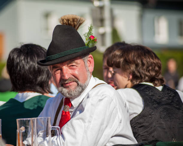 mann in tracht beim oktoberfest in einer kleinen stadt in österreich - saint johann stock-fotos und bilder