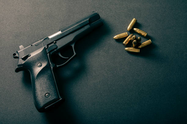 istock black gun and yellow bullet on black background 1376777248