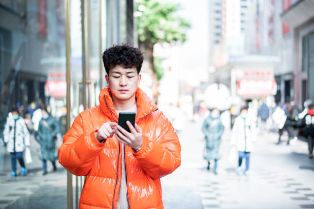 istock Asian handsome young man using smartphone in city street 1376798040