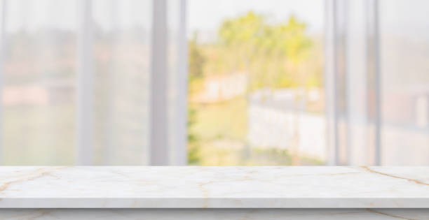 Empty marble table top with blur window curtain background stock photo