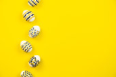 White eggs with a geometric gold and black pattern on a white background. Copy space. Flat lay