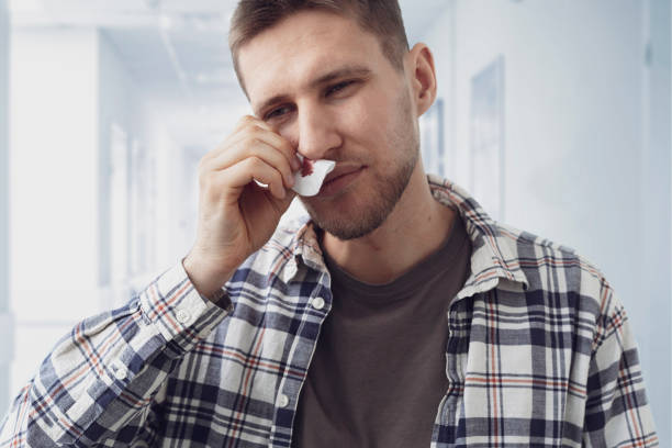 young man has broken nose with blood going out it and stop it with a napkin, unfortinate accident young man has broken nose with blood going out it and stop it with a napkin, unfortinate accident painfully stock pictures, royalty-free photos & images