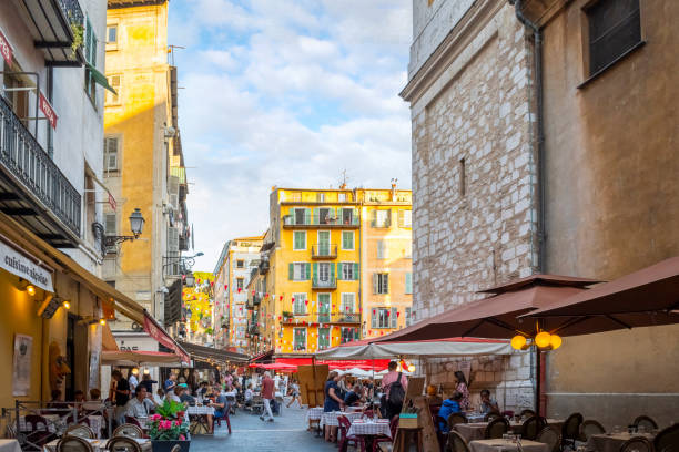 a busy afternoon at the colorfully decorated place rossetti as tourists crowd the shops and cafes in the old town area of nice, france, on the french riviera. - city of nice restaurant france french riviera imagens e fotografias de stock
