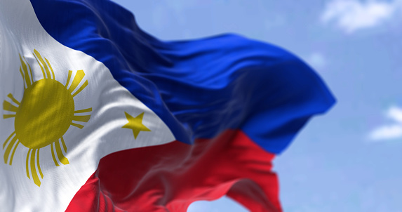 Detail of the national flag of the Philippines waving in the wind on a clear day. The Philippines is an archipelagic country in Southeast Asia. Selective focus.