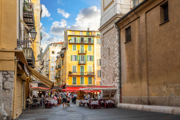 a busy afternoon at the colorfully decorated place rossetti as tourists crowd the shops and cafes in the old town area of nice, france, on the french riviera. - city of nice restaurant france french riviera imagens e fotografias de stock