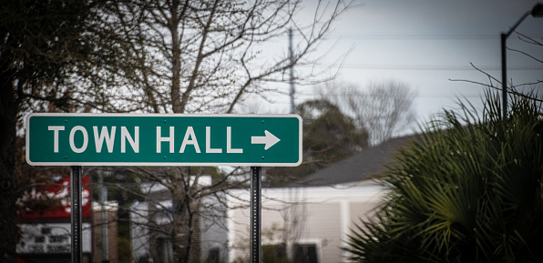 A sign directing towards a rural town hall.