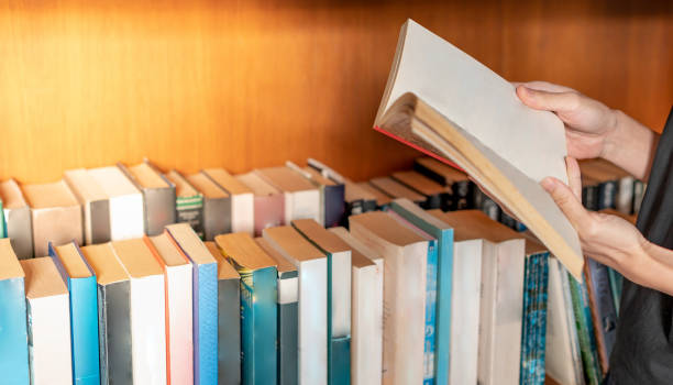 istock Female hand holding notebook and reading book for relaxing and the knowledge while sitting on the sofa in the living room in their house. 1376968720