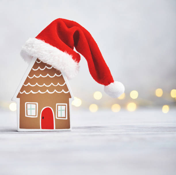 istock Christmas arrangement with house wearing Santa hat in a bright setting 1377001507