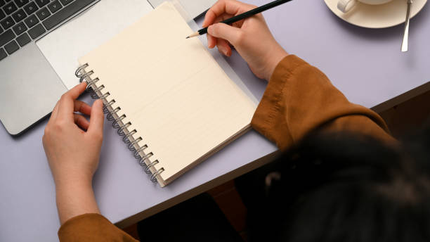 istock Top view, Female writing on her diary in creative purple office desk. 1377035842