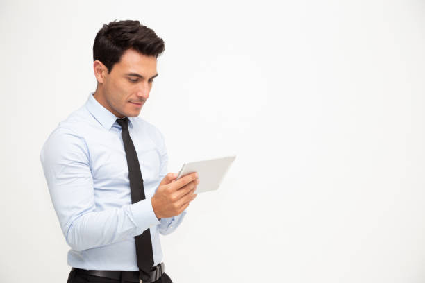 młody biznesmen używający tabletu pod ręką izolowanego na białym tle - book holding necktie businessman zdjęcia i obrazy z banku zdjęć