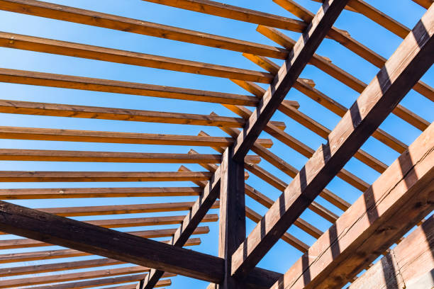 Diagonal wooden slatted ceiling casting geometric patterns in warm tones.