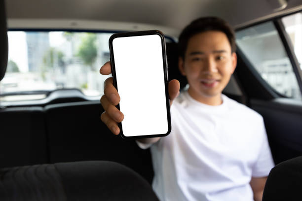 istock Passenger man showing empty application on mobile phone while sitting on back seat in car 1377046194