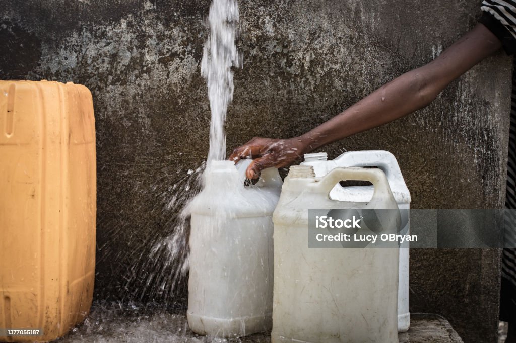 Water Crisis-Dame Marie, Haiti Haitians fill cans at a water point daily Poverty Stock Photo