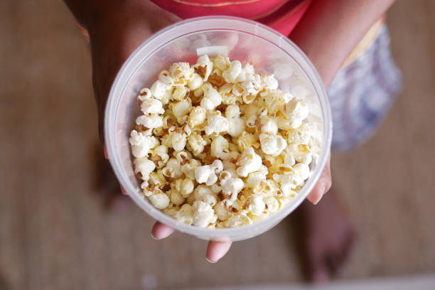 istock young man eating popcorn close up 1377056431