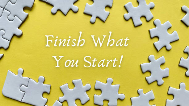 istock Finish what you start text on yellow background with white jigsaw puzzle missing pieces. 1377071450