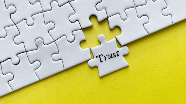 istock Trust word on a jigsaw puzzle with yellow background. 1377072003