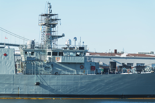 The communications masts and structures of HMAS Canberra are surrounded by scaffolding when docked at Garden Island naval base in Sydney Harbour.  She is one of two Canberra Class amphibious assault ships of Royal Australian Navy. This image was taken on an overcast and windy afternoon on 25 November 2023.