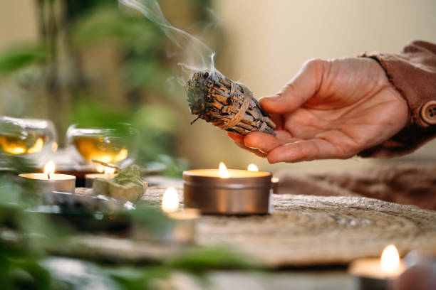 istock Woman hands burning white sage, before ritual on cadle 1377163622