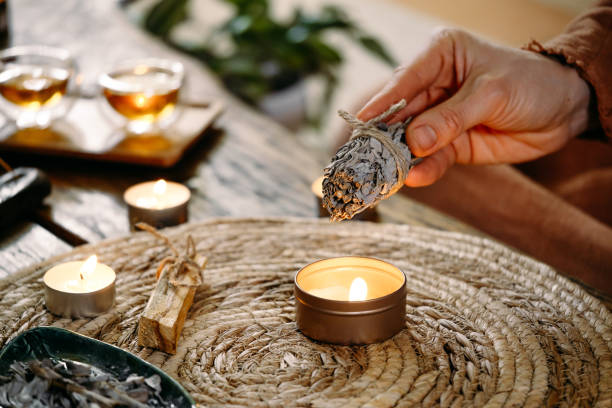 istock Woman hands burning white sage, before ritual on cadle 1377179476