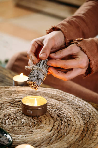 istock Woman hands burning white sage, before ritual on cadle 1377190680