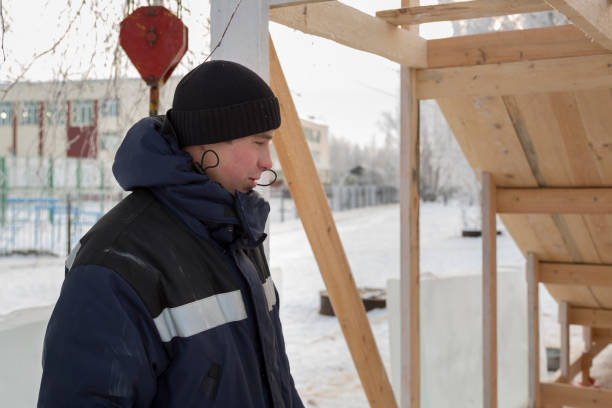 istock Portrait of a builder in a black knitted and blue winter jacket 1377220960