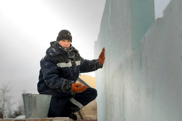 istock Worker covers the joints of ice panels with wet snow 1377223305