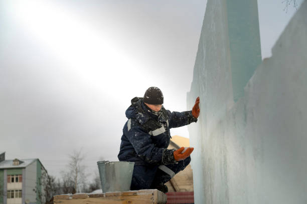 istock Worker covers the joints of ice panels with wet snow 1377223314