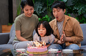 若いアジアのカップルは、彼らの娘の誕生日を祝います
