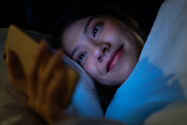 istock Young Asian woman using smartphone at midnight 1377232430