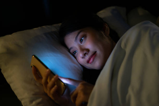 istock Young Asian woman using smartphone at midnight 1377232434