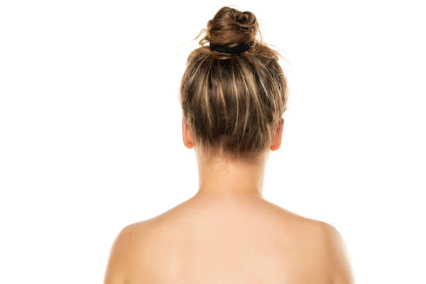 rear view of a blond woman with bun on white background