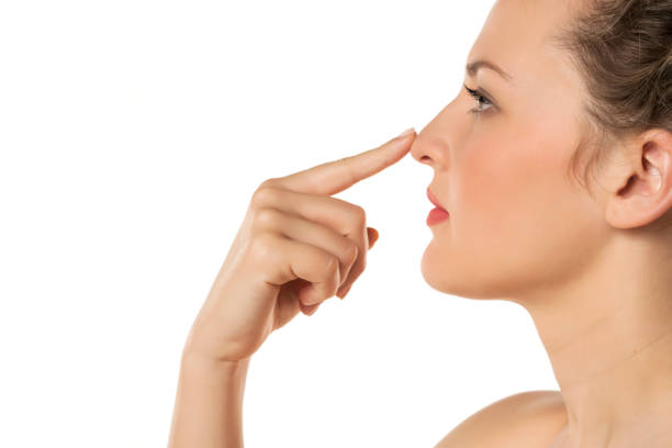 istock woman touching her nose 1377271958