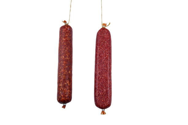 istock Two hanging raw smoked sausage isolated on white background 1377289213