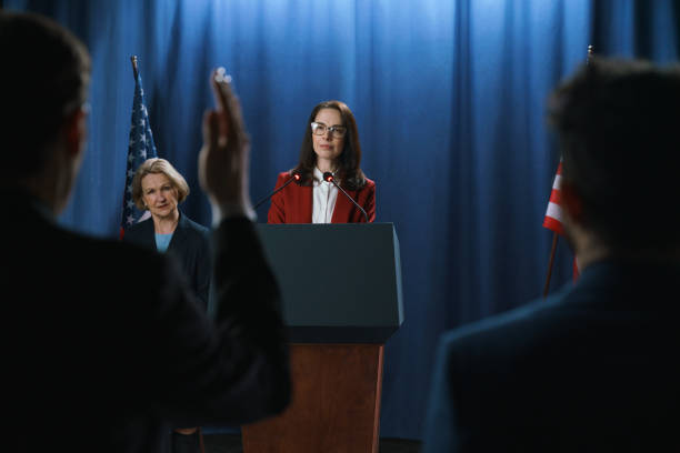 a journalist from the audience rising a hand to ask the question after the politician's  speech at the debates - press conference public speaker politician speech imagens e fotografias de stock