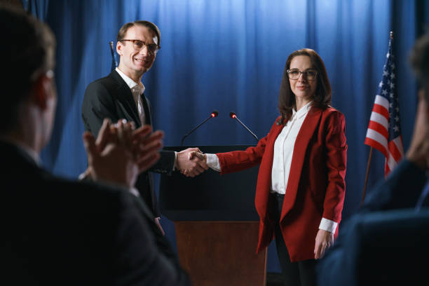 istock White politicians shaking hands at the debates, standing on a blue background with American flag 1377297771