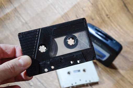 Audio cassette. Retro music medium, compact cassette for tape recorder, audio cassette in the hands of a man. Retro audio.