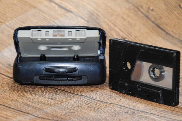 istock Retro audio cassettes next to a portable player to play compact cassettes. 1377299337