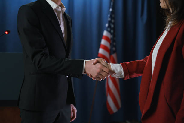 handschlag zweier politiker auf blauem grund mit amerikanischer flagge - president of russia stock-fotos und bilder