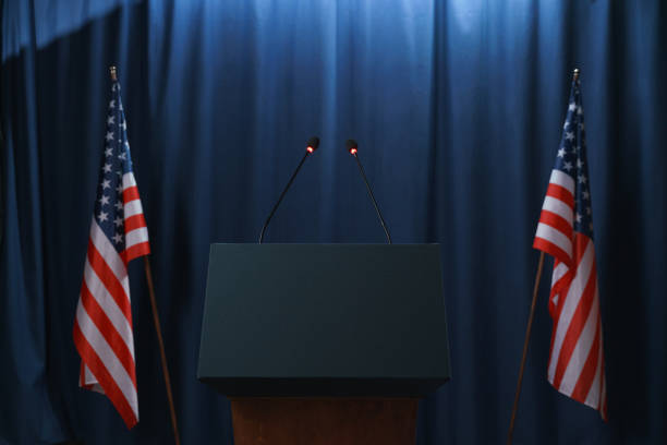 Empty stage before or after the debates with a pedestal and American flags from both sides Empty stage before or after the debates with a pedestal and American flags from both sides presidential election stock pictures, royalty-free photos & images