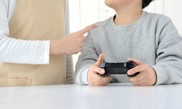 mother scolding for child playing video game - childs game imagens e fotografias de stock